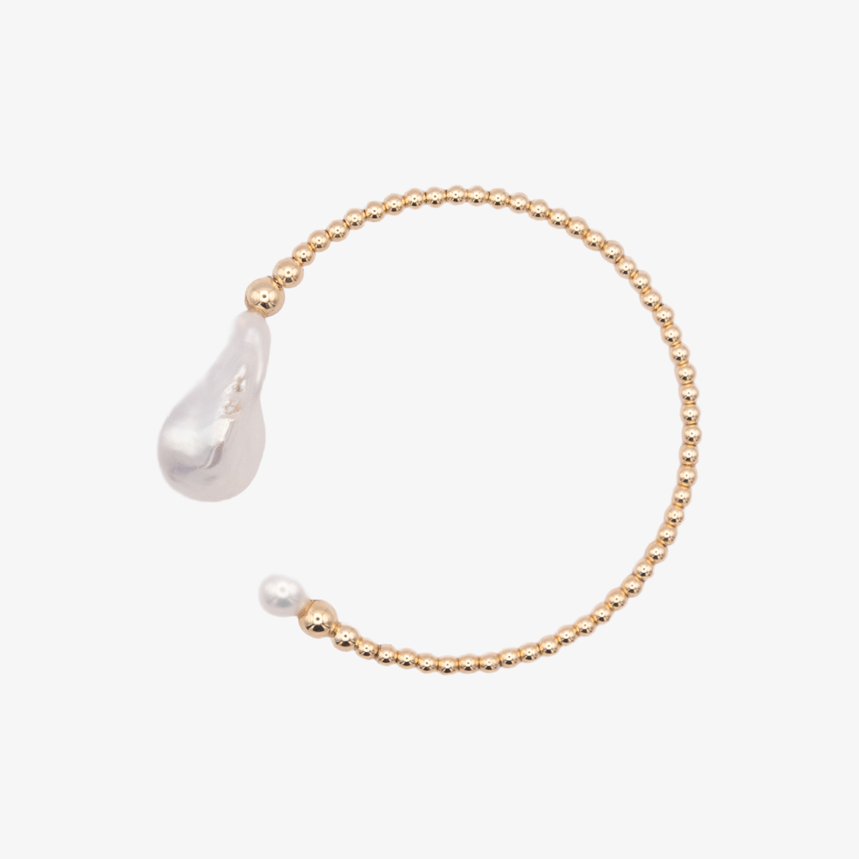 Gold bracelet with a teardrop-shaped pearl on a white background